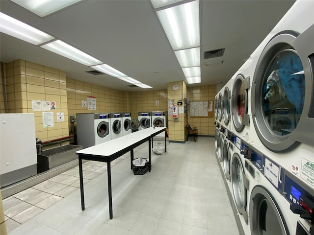 clothes washing area featuring independent washer and dryer and stacked washer and dryer