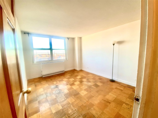 unfurnished room featuring parquet flooring and radiator