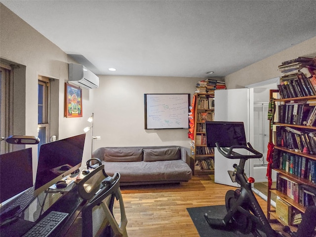 living room with a wall unit AC and light wood-type flooring