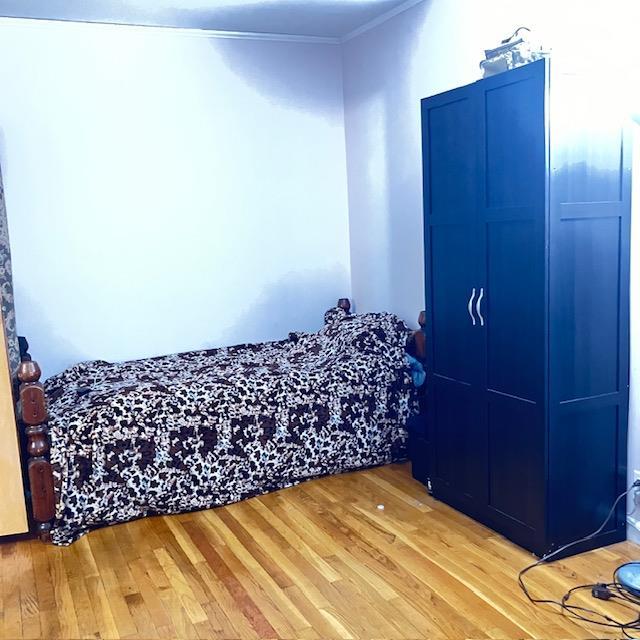 bedroom featuring hardwood / wood-style floors and ornamental molding