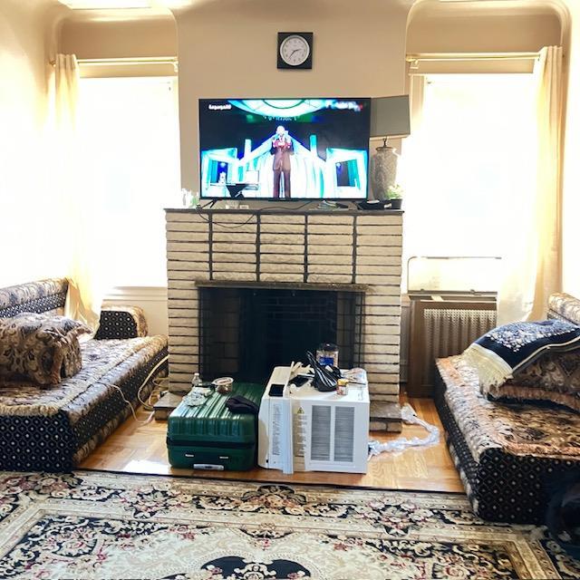 living room featuring a fireplace and a wall unit AC