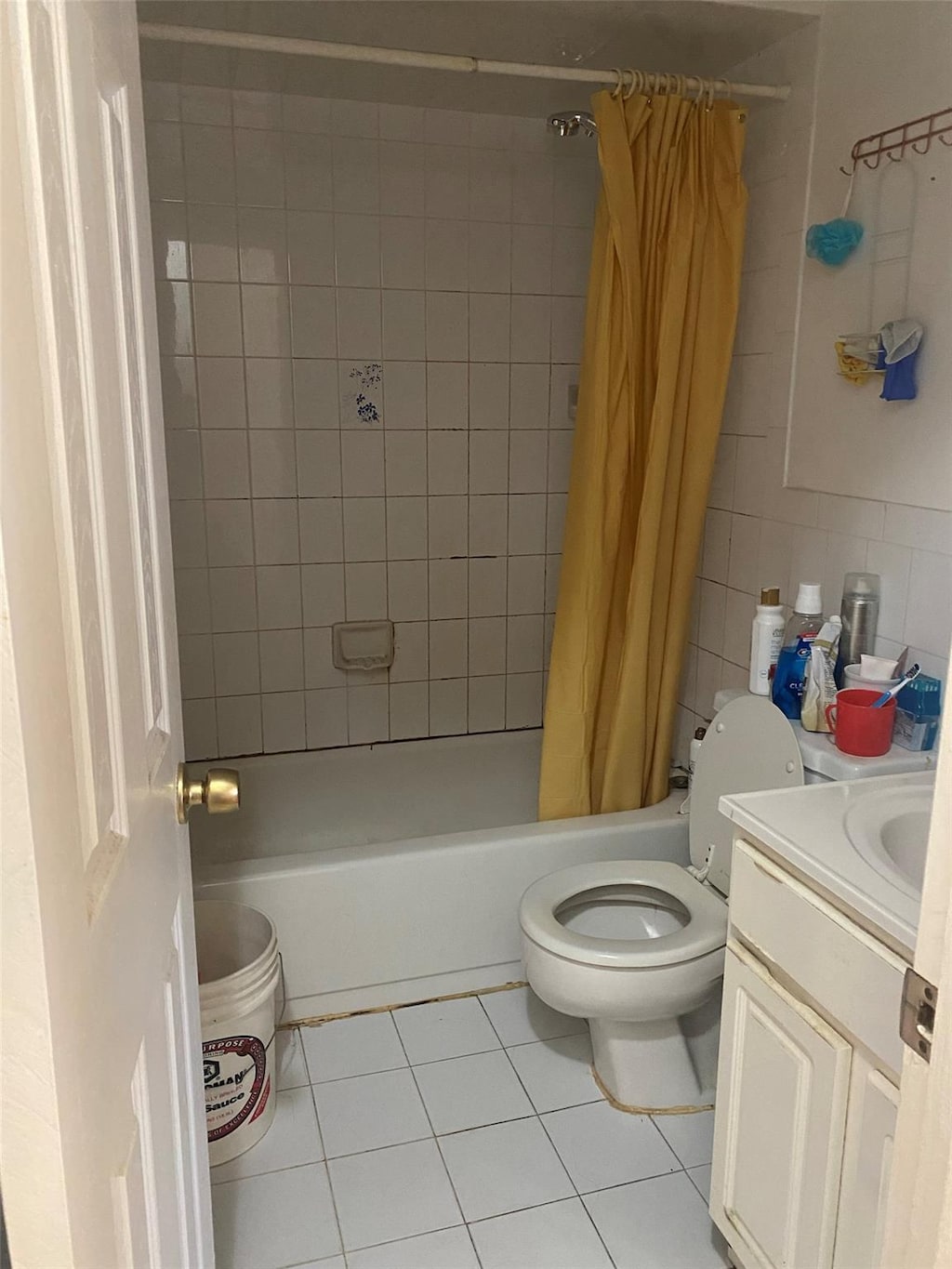 full bathroom with tile patterned floors, backsplash, shower / bath combination with curtain, toilet, and vanity