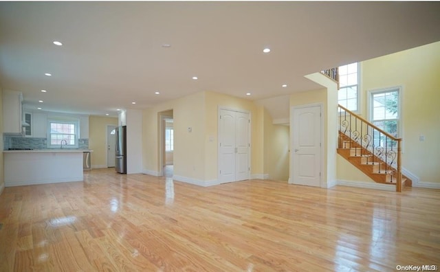 unfurnished living room featuring light hardwood / wood-style floors and sink