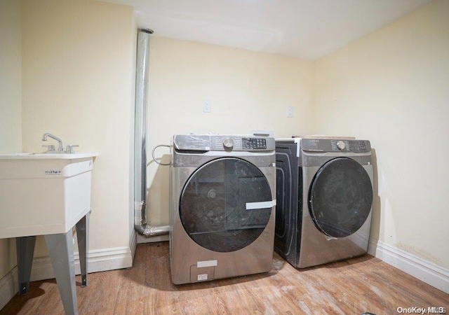 laundry area with washer and dryer and light wood-type flooring