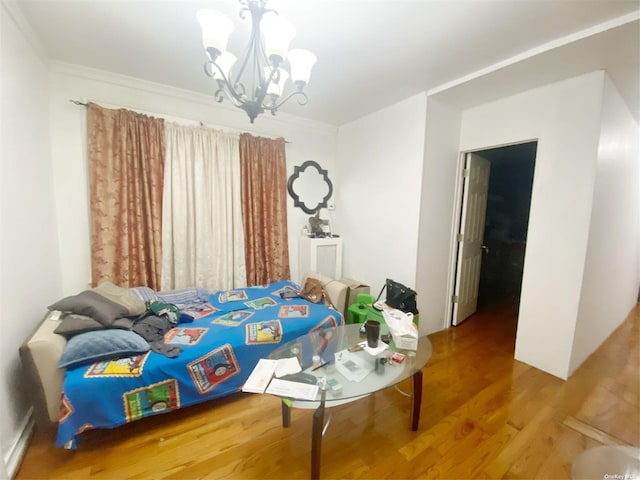 bedroom featuring wood-type flooring, crown molding, and a chandelier