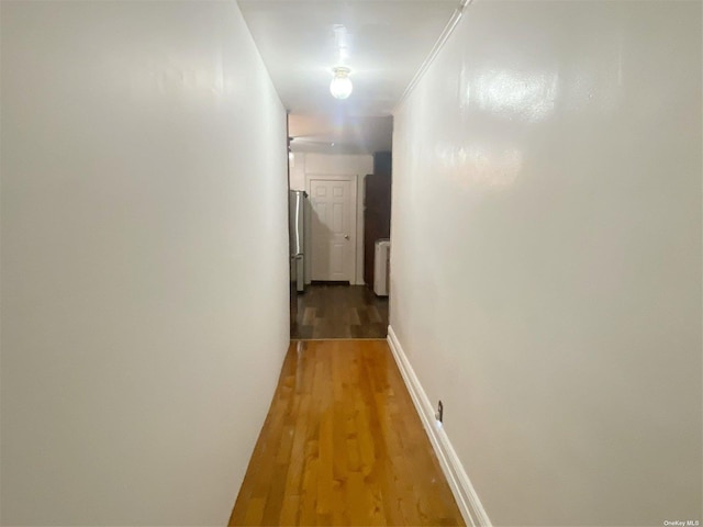 corridor with hardwood / wood-style floors and radiator heating unit