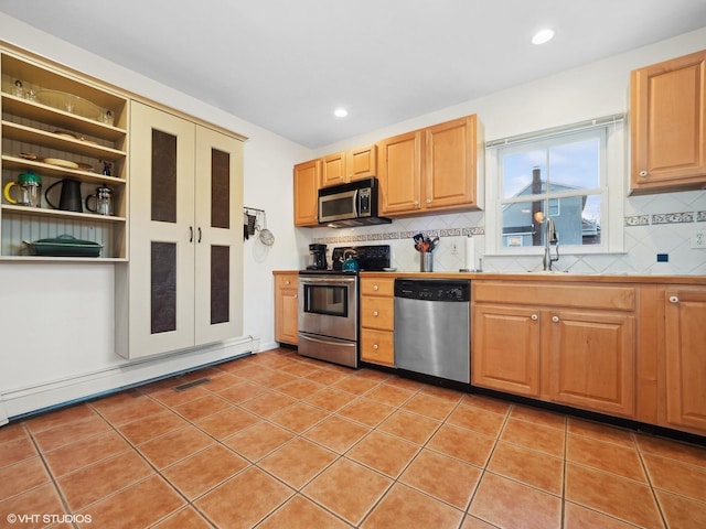 kitchen featuring appliances with stainless steel finishes, backsplash, sink, a baseboard radiator, and light tile patterned flooring