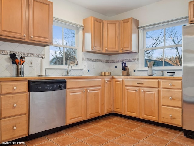 kitchen with sink, light tile patterned floors, stainless steel appliances, and tasteful backsplash