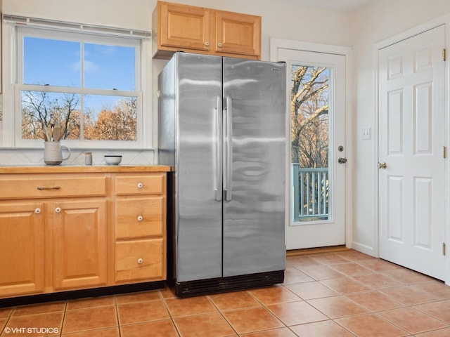 kitchen featuring light tile patterned floors and stainless steel refrigerator