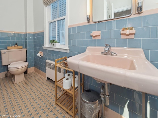 bathroom featuring tile patterned flooring, toilet, tile walls, and radiator