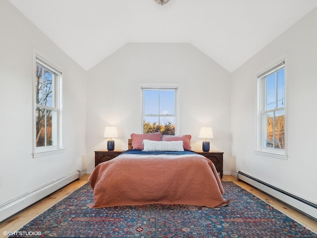 bedroom featuring hardwood / wood-style flooring, vaulted ceiling, and a baseboard heating unit