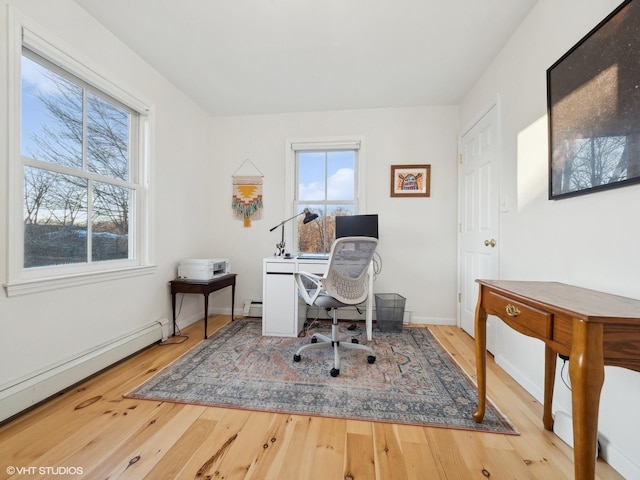 office area with light hardwood / wood-style flooring and a baseboard heating unit