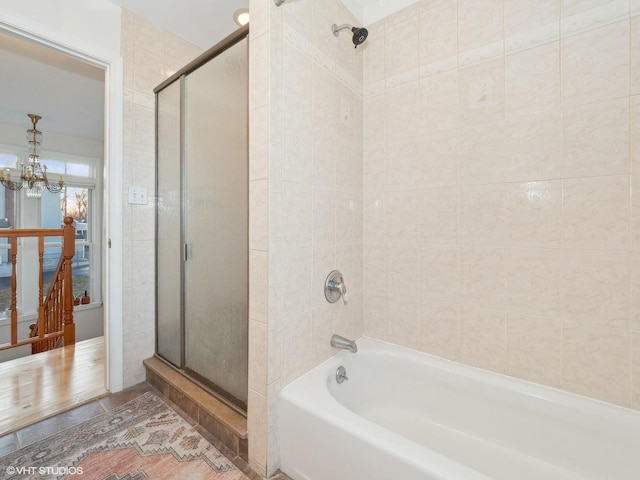 bathroom featuring a notable chandelier and independent shower and bath