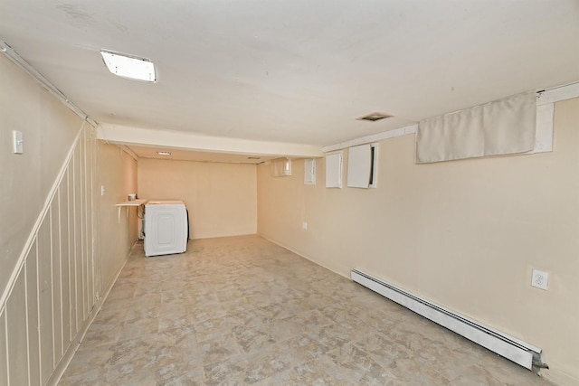 basement with a baseboard radiator and washer / dryer