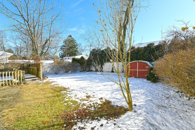 yard layered in snow featuring a storage unit