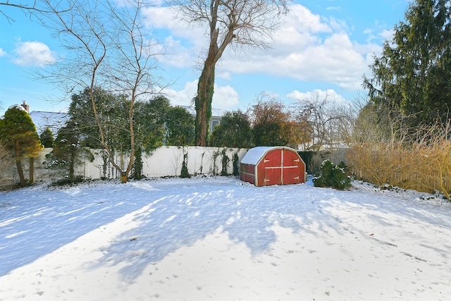 yard covered in snow featuring a storage unit