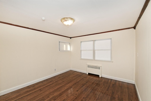 empty room with dark hardwood / wood-style flooring, radiator heating unit, and ornamental molding