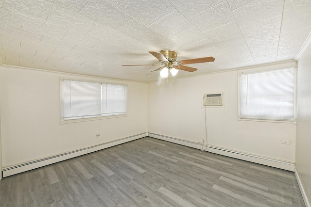 empty room featuring an AC wall unit, crown molding, ceiling fan, baseboard heating, and wood-type flooring