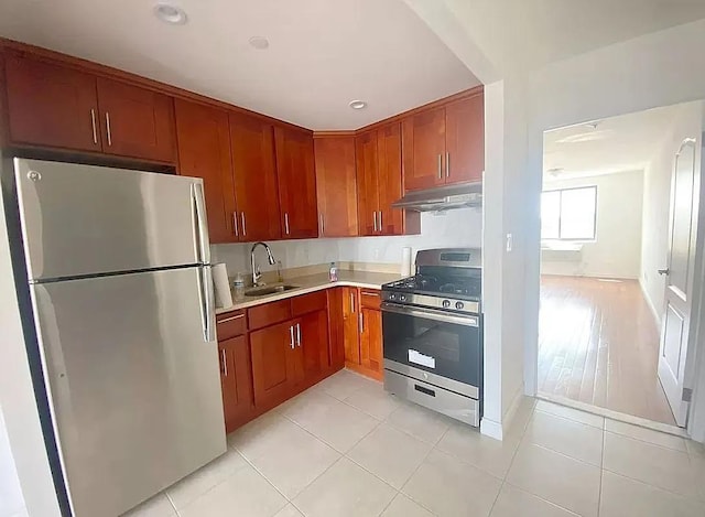 kitchen with appliances with stainless steel finishes, light tile patterned floors, and sink