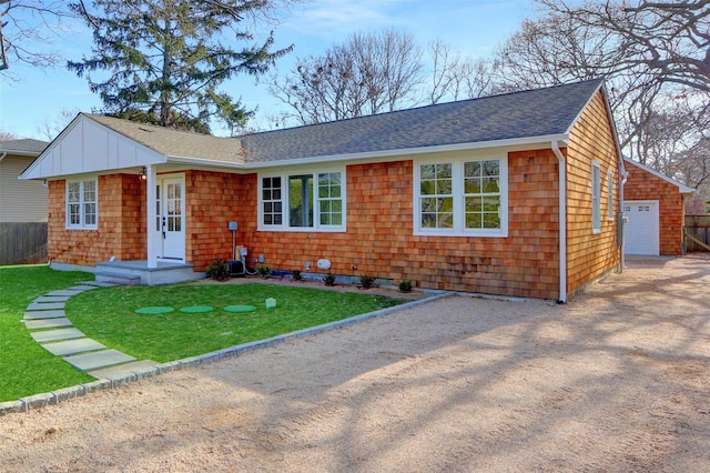 ranch-style home with an outbuilding, a garage, and a front lawn