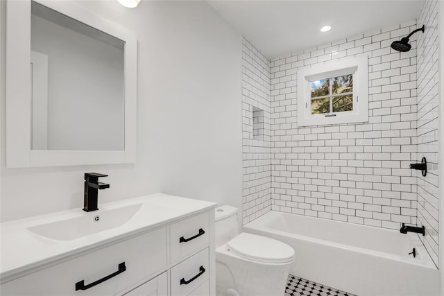 full bathroom featuring tiled shower / bath, vanity, and toilet