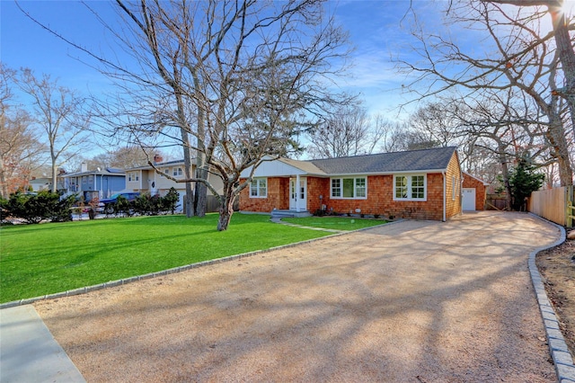 ranch-style house featuring a garage and a front lawn