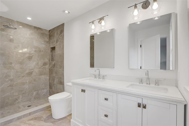 bathroom featuring vanity, toilet, and tiled shower