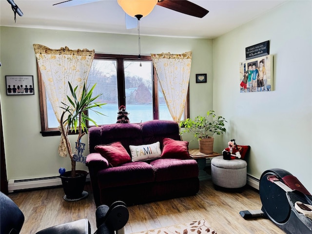 living room featuring wood-type flooring, a baseboard radiator, and ceiling fan