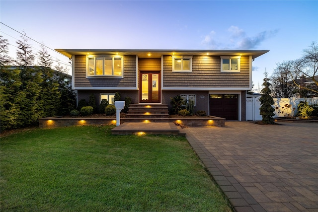 split foyer home with a garage and a yard