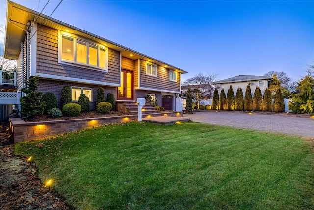 bi-level home with a lawn and a garage