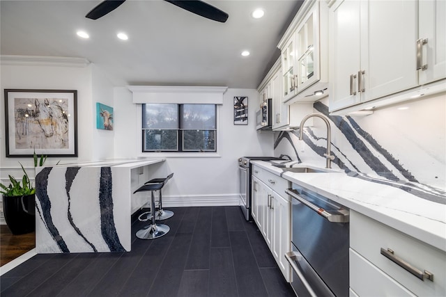 kitchen featuring sink, crown molding, stainless steel appliances, white cabinets, and light stone counters