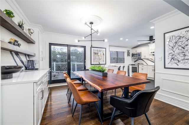 dining room with dark hardwood / wood-style floors, ceiling fan with notable chandelier, and ornamental molding