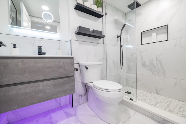 bathroom featuring toilet, vanity, and a tile shower