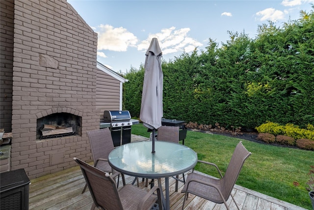 view of patio / terrace with a wooden deck, grilling area, and an outdoor brick fireplace