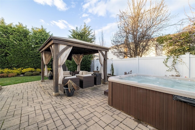 view of patio with a gazebo, a hot tub, and an outdoor hangout area