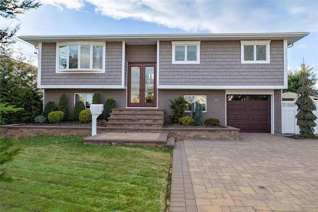 bi-level home featuring a front yard, a garage, and french doors