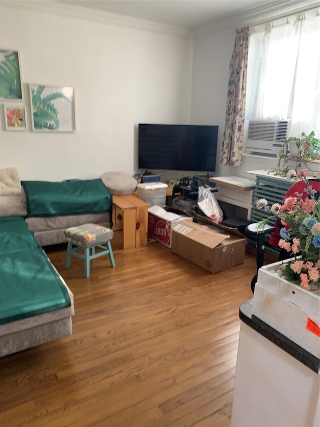 living room with crown molding, light hardwood / wood-style flooring, and cooling unit