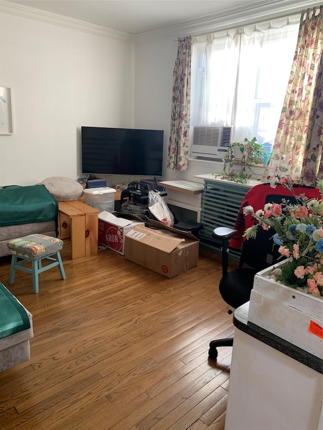 living room with hardwood / wood-style floors, cooling unit, and ornamental molding