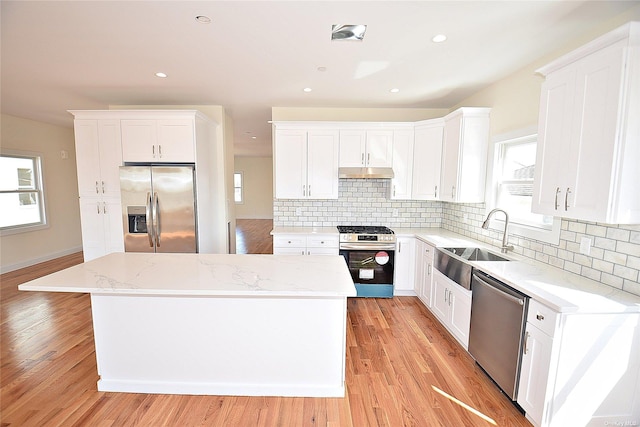 kitchen featuring a kitchen island, sink, white cabinetry, and stainless steel appliances