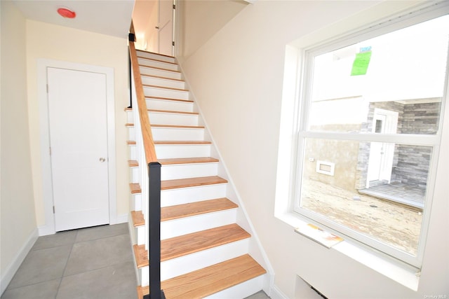 stairway featuring tile patterned flooring