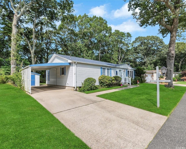 view of front of home with a front yard, a shed, and a carport