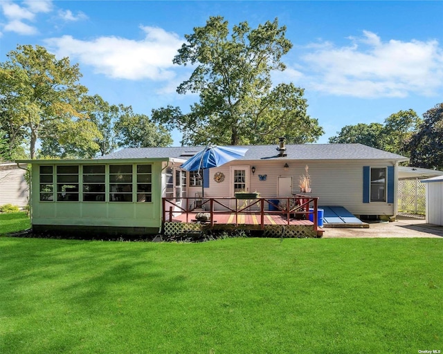 back of house with a lawn, a wooden deck, and a sunroom