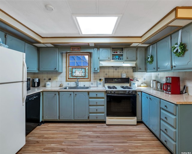 kitchen featuring light wood-type flooring, white appliances, tasteful backsplash, and sink