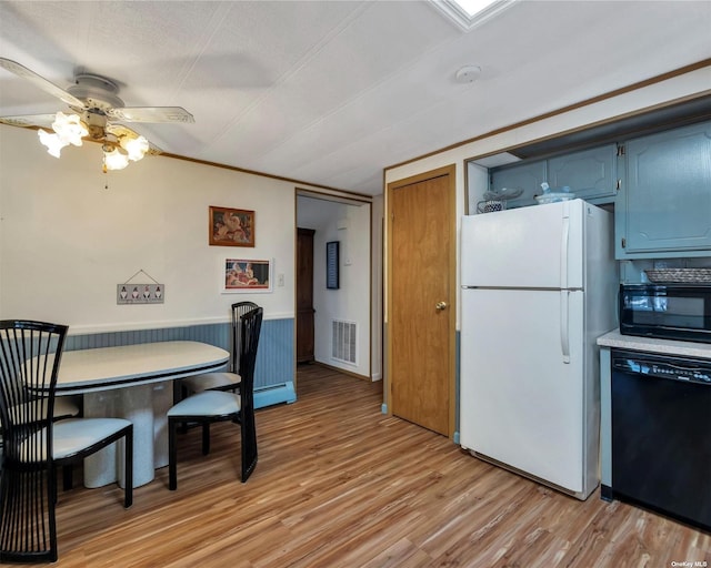 dining room with ceiling fan, a baseboard radiator, light hardwood / wood-style floors, a textured ceiling, and wooden walls