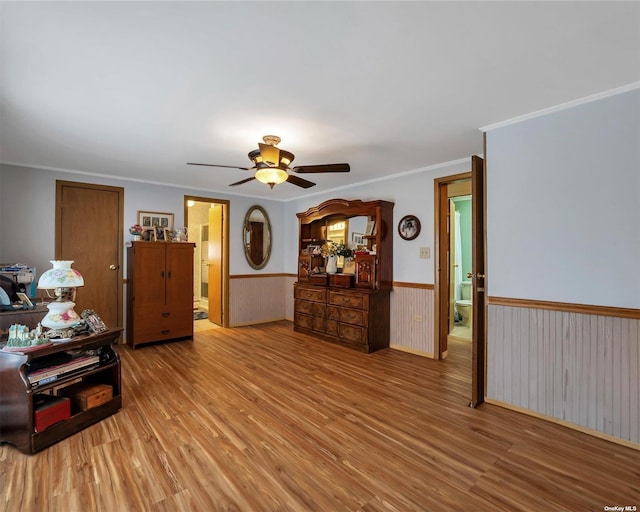 living room featuring hardwood / wood-style flooring, ceiling fan, and crown molding