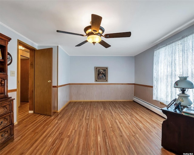 empty room with a baseboard radiator, light hardwood / wood-style flooring, ceiling fan, and ornamental molding