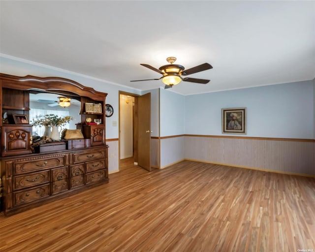 unfurnished living room featuring light hardwood / wood-style floors and crown molding