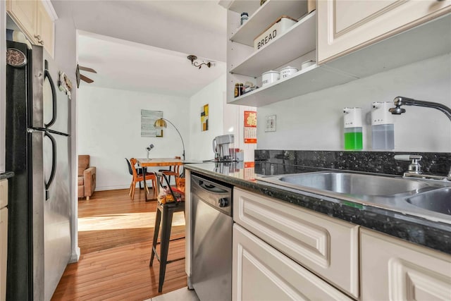 kitchen with sink, stainless steel appliances, and light hardwood / wood-style floors