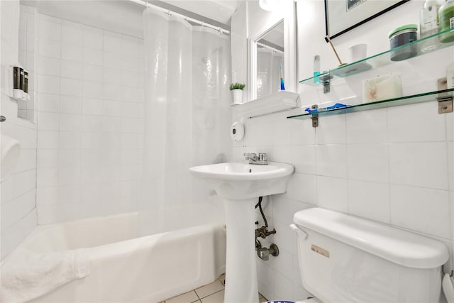 bathroom featuring tile patterned flooring, shower / bath combination with curtain, tile walls, and toilet