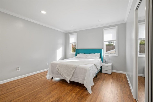 bedroom with ornamental molding and hardwood / wood-style flooring